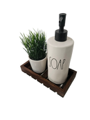 a soap dispenser and a potted plant on a tray
